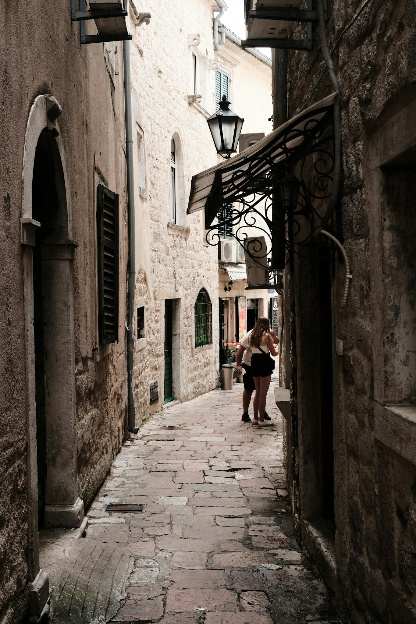 A picturesque narrow alley in Kotor, Montenegro's historic old town, showcasing medieval architecture.