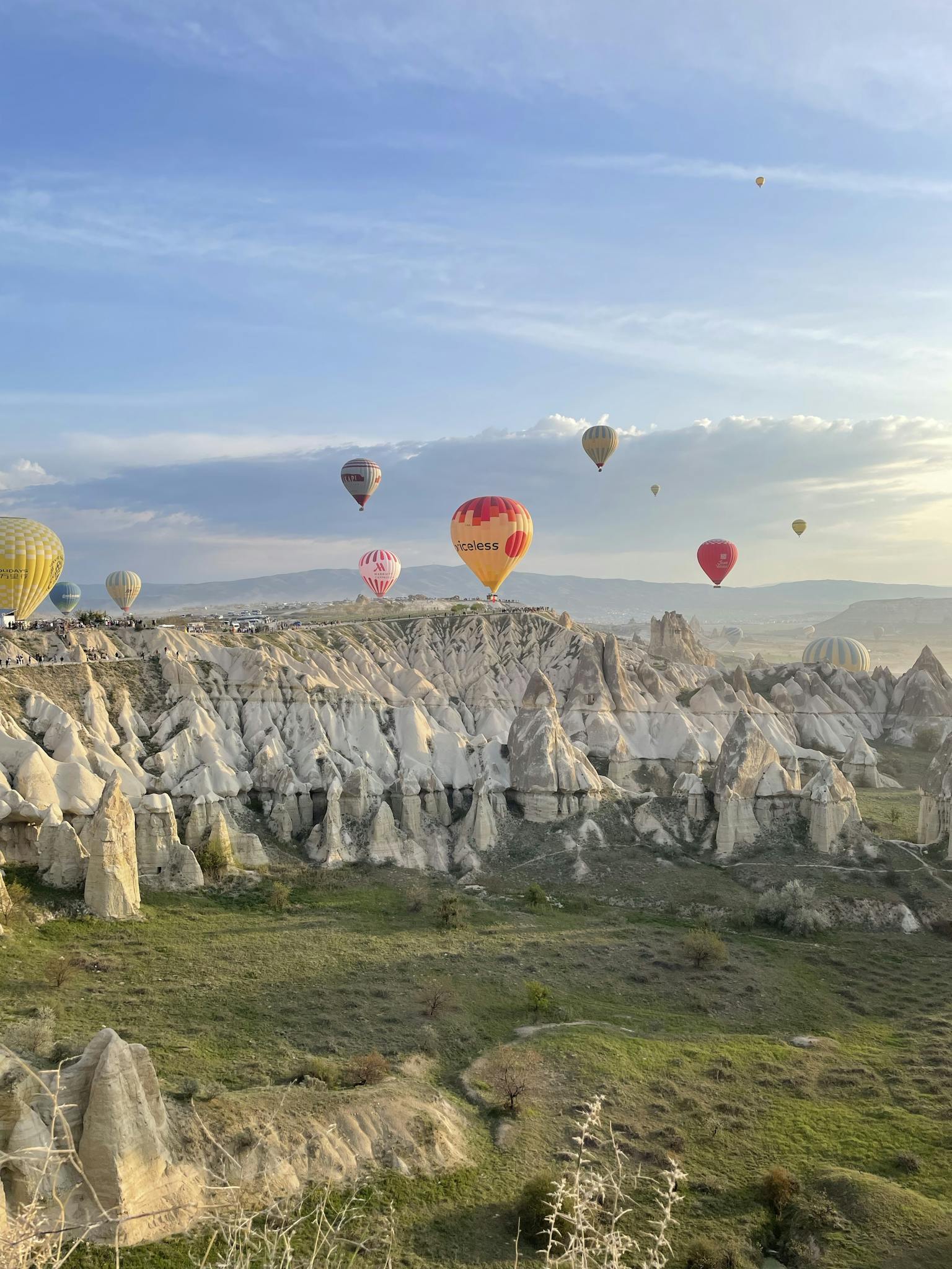 Breathtaking view of hot air balloons floating over Cappadocia's fairy chimneys at sunrise.