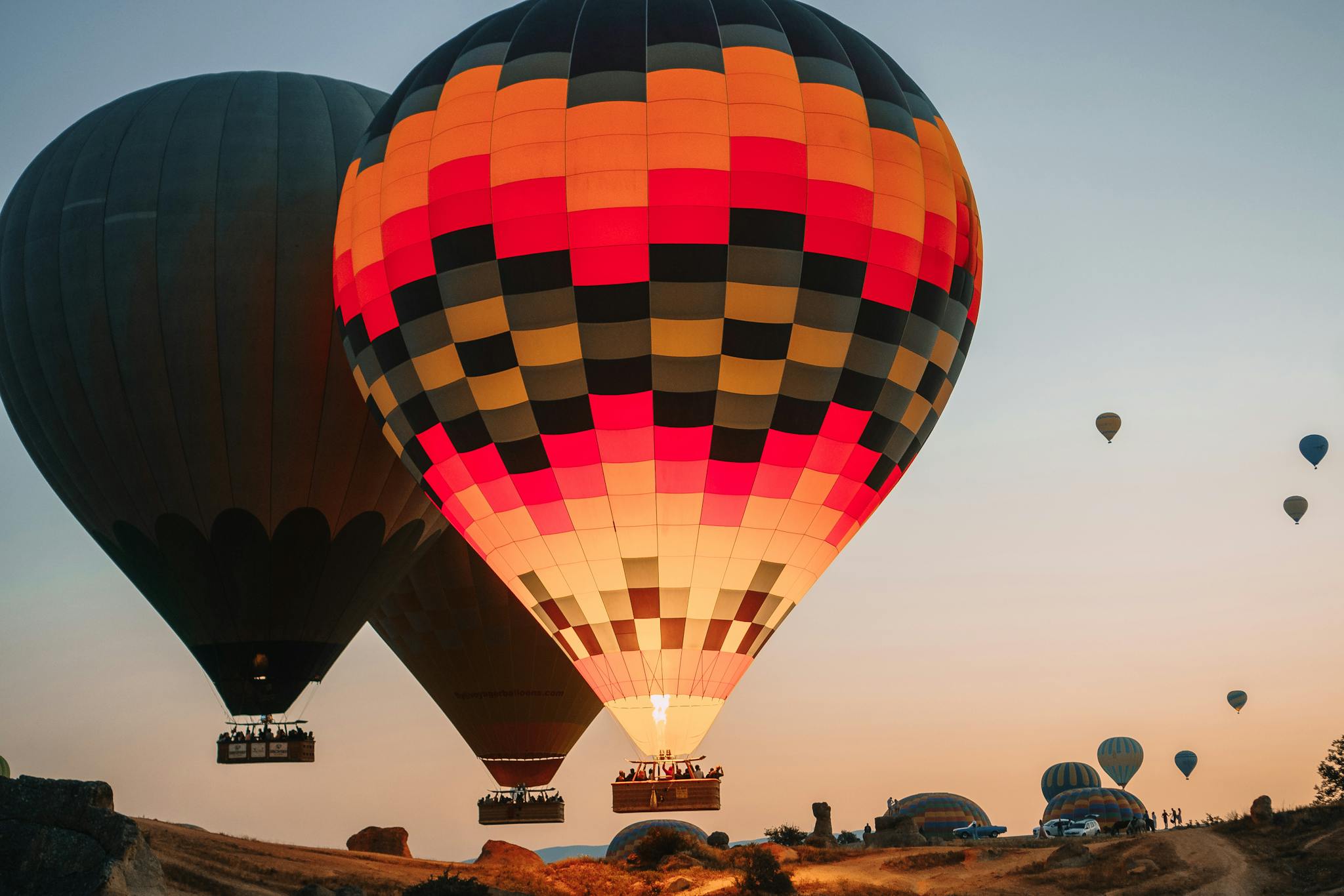 Vibrant hot air balloons soaring over Cappadocia at sunset, capturing a serene travel experience.